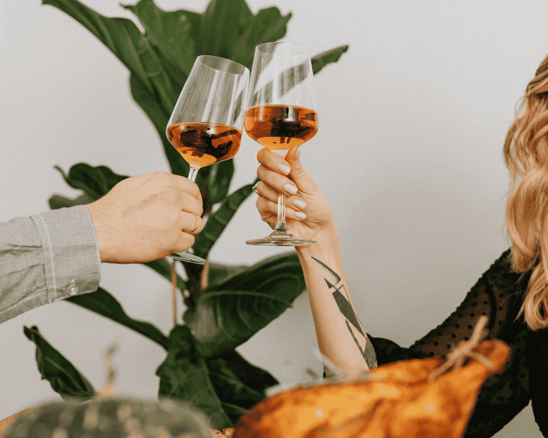 Couple celebrating with orange wine toasts, highlighting the vibrant color and festive charm of skin contact wines
