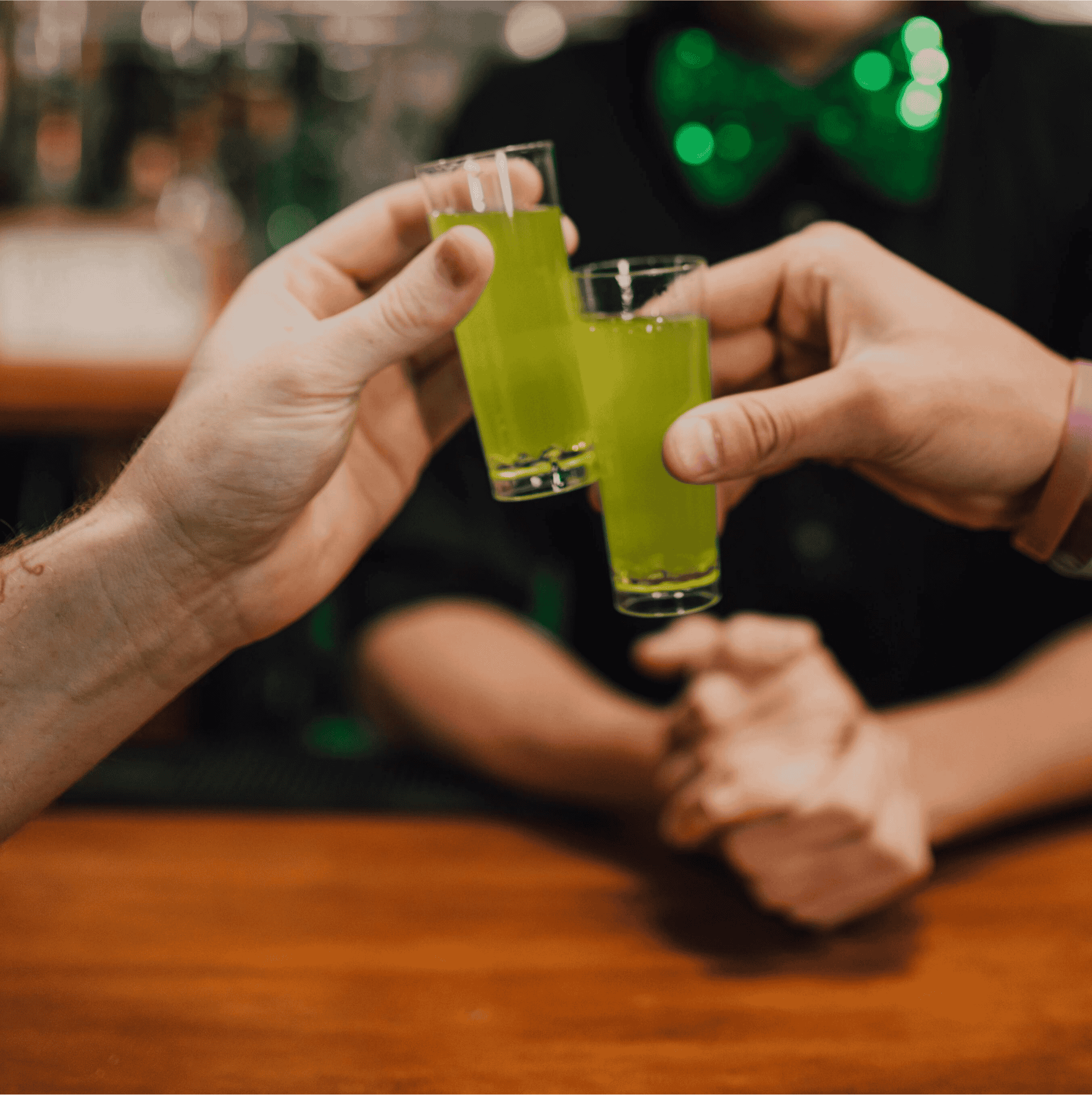 Friends toasting with green cocktails made from Irish whiskey, a classic Irish drink for St. Patricks Day gatherings