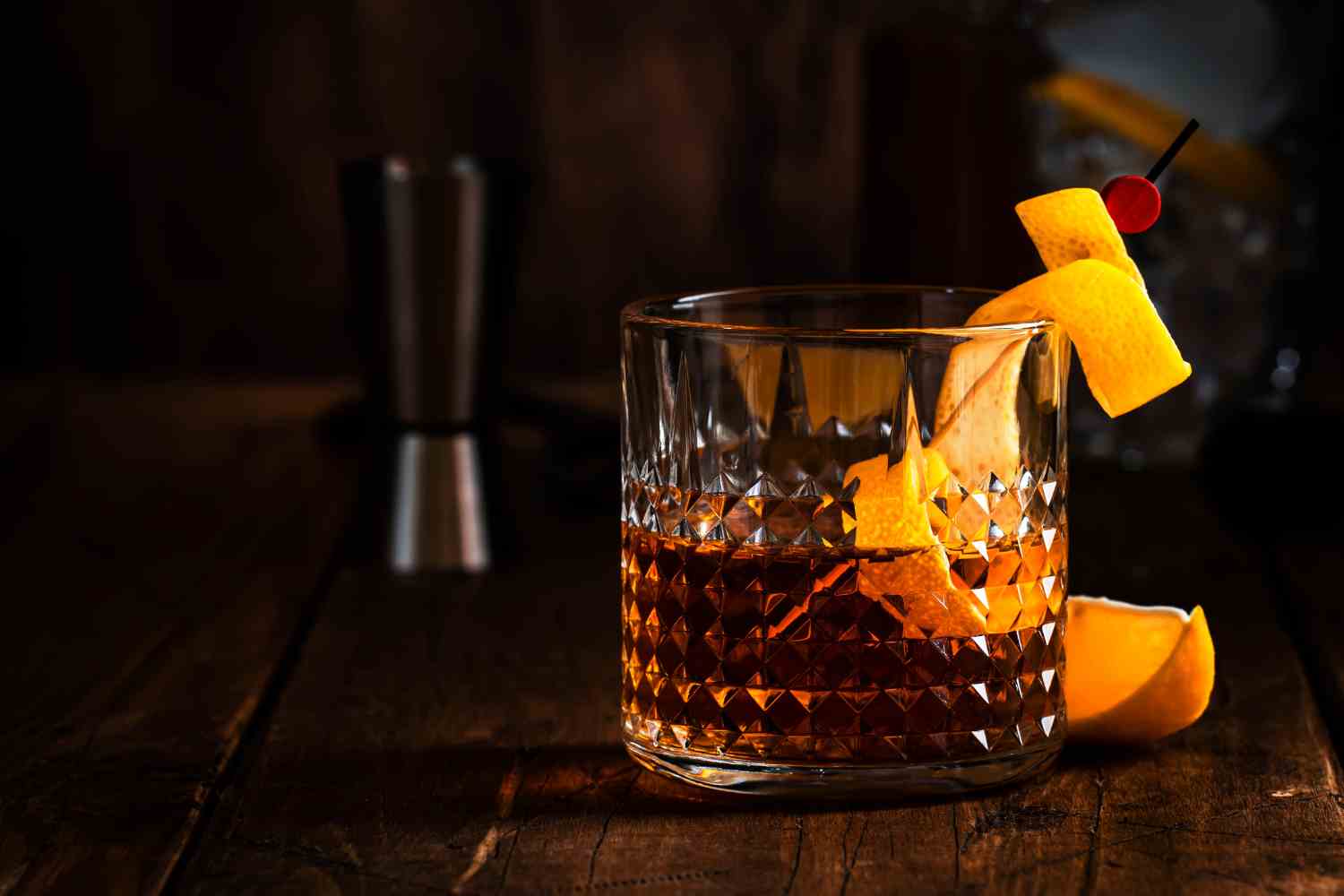 Bourbon whiskey cocktail in a crystal glass with orange peel garnish, a warm and classic fall drink