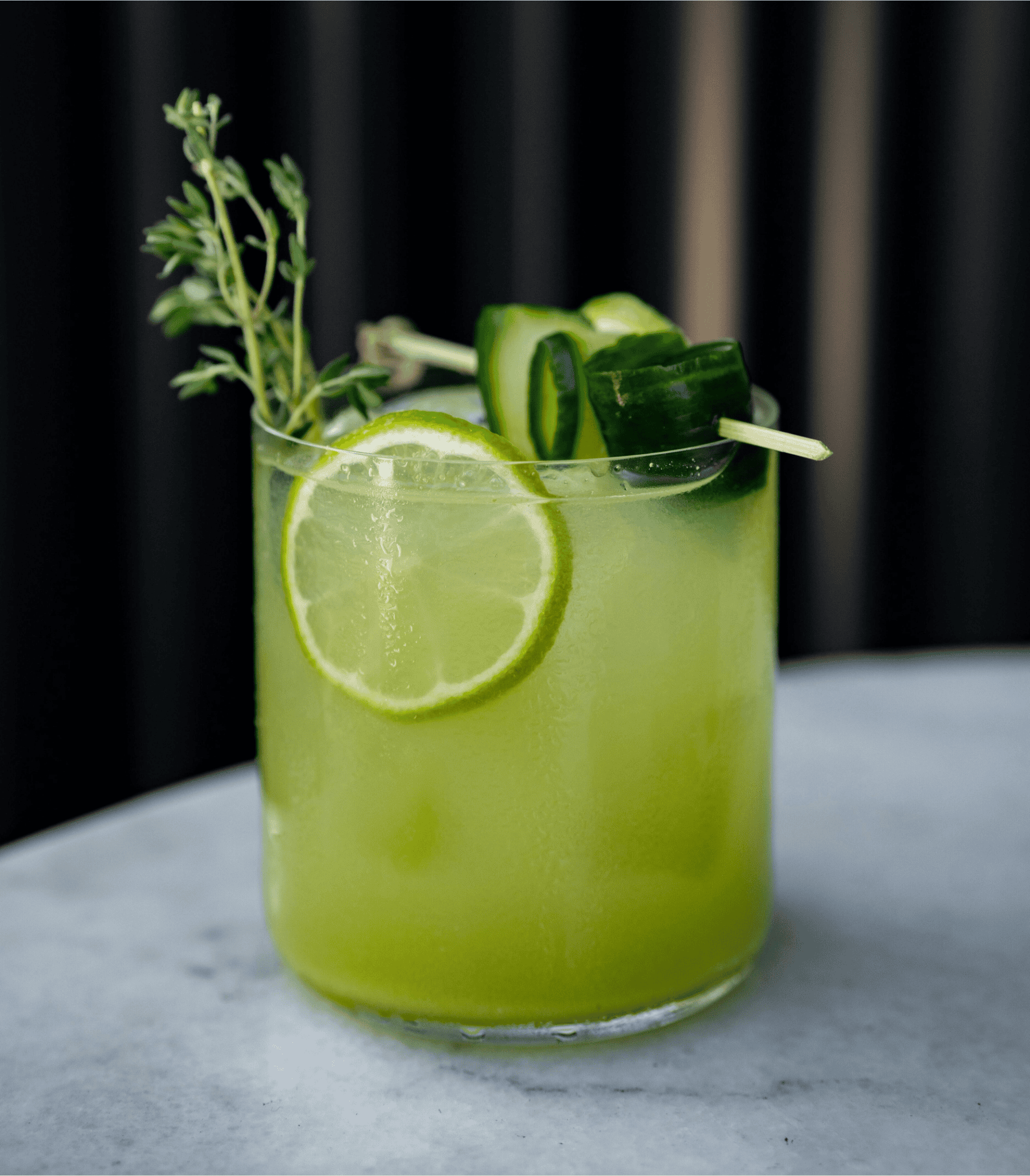 Refreshing green cocktail garnished with lime and herbs, a vibrant Irish drink ideal for St. Patricks Day celebrations