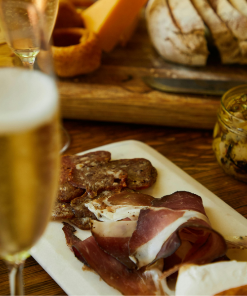 Charcuterie board with cured meats and cheese paired with sparkling wine, highlighting wine and deli pairings and NYC food pairings