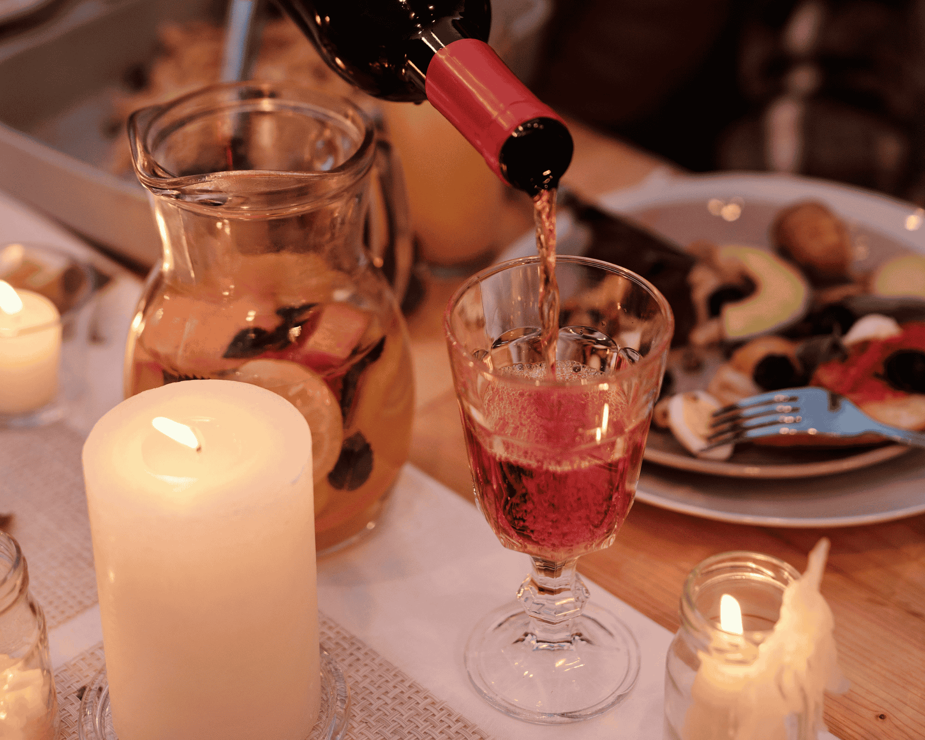 Pouring red wine at a cozy winter dinner table, the perfect setting to enjoy warm wines and seasonal comfort